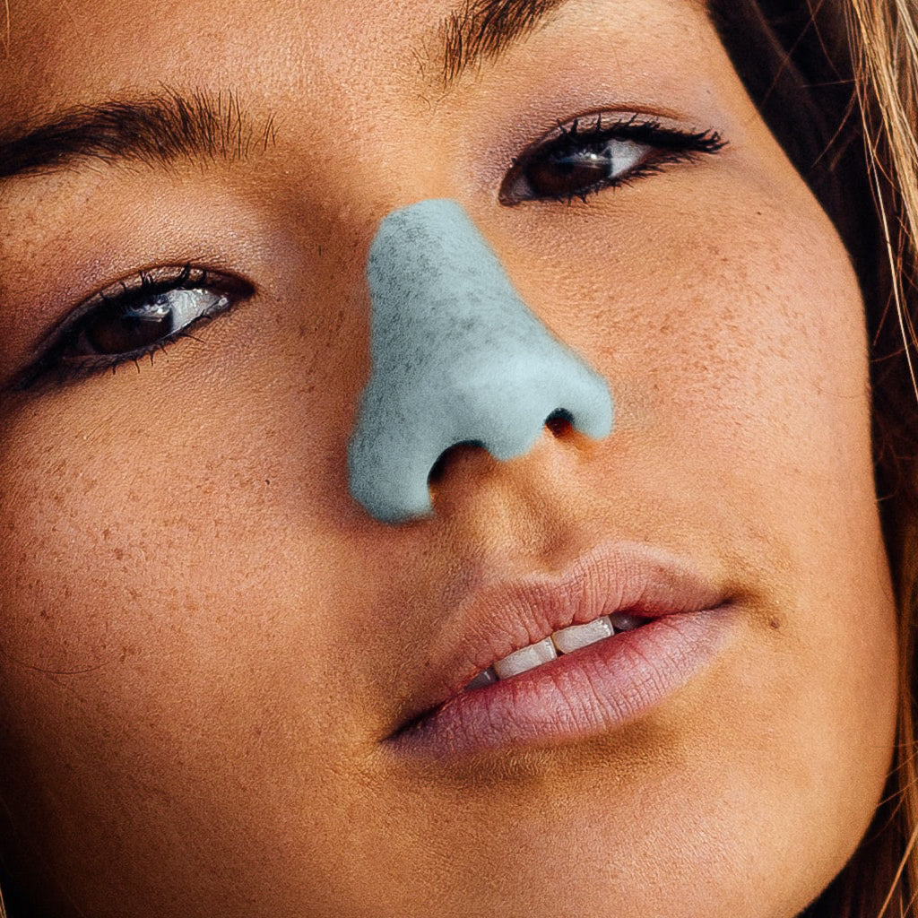 Woman wearing the blue, eco-friendly, Nözscreen sunscreen on her nose